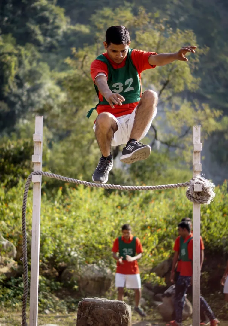 Participant clearing an outdoor rope obstacle